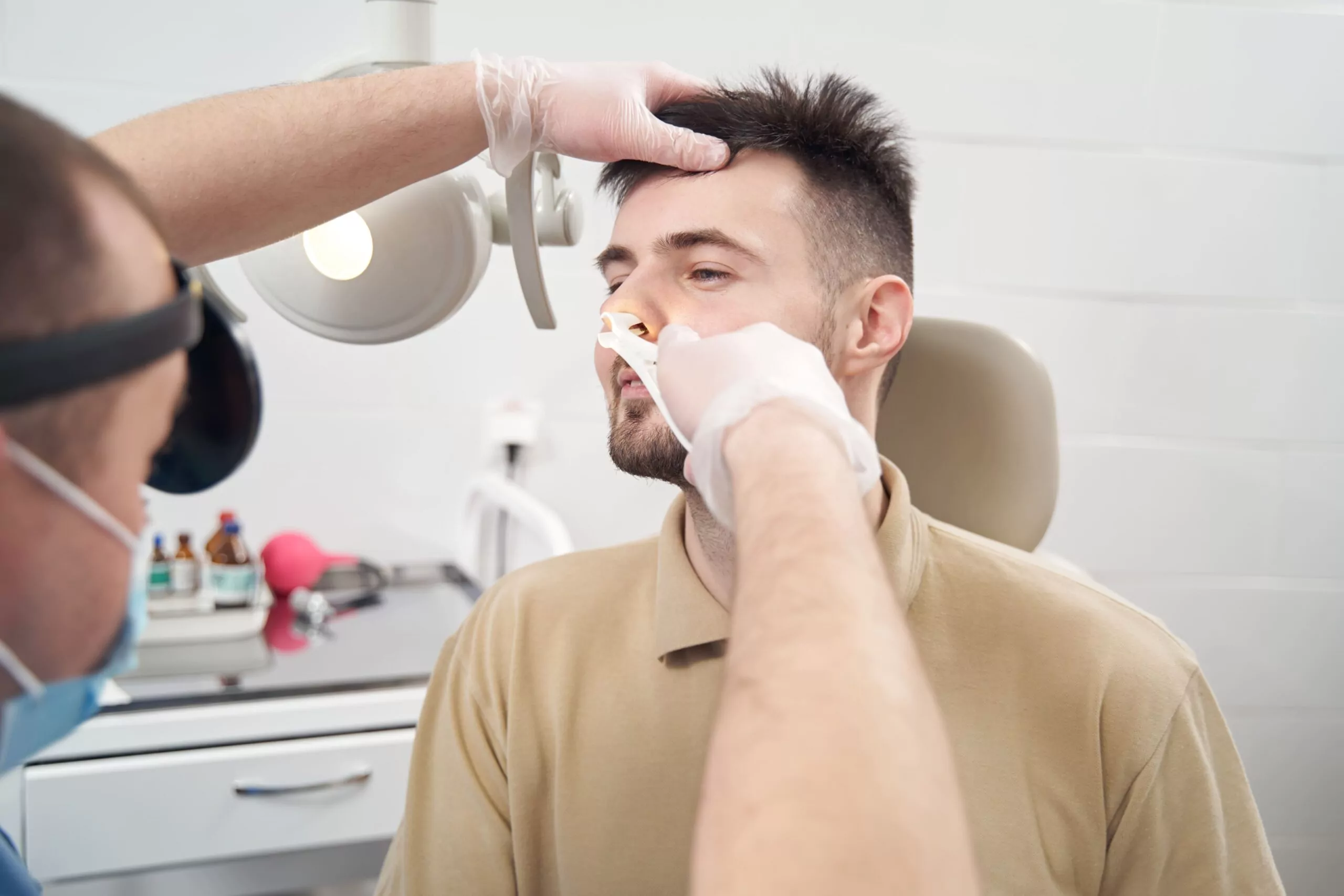 Dr. Gan performing nasal examination procedure